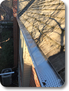 Installing mill finish gutter guard protection on a customer's house with wood shake.